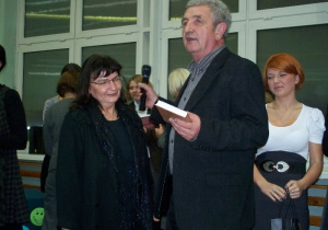 Kazimierz Tischner w wręcza Ewie Sztombce książkę w obecności uczennicy Natalii Bogdan
